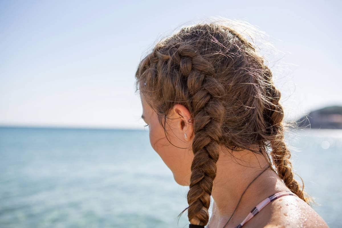 Infographic showing common mistakes vs. pro techniques for casual braided ponytails: Over-tightening vs. relaxed tension, plastic elastics vs. fabric ties, slicked-back vs. face-framing strands.