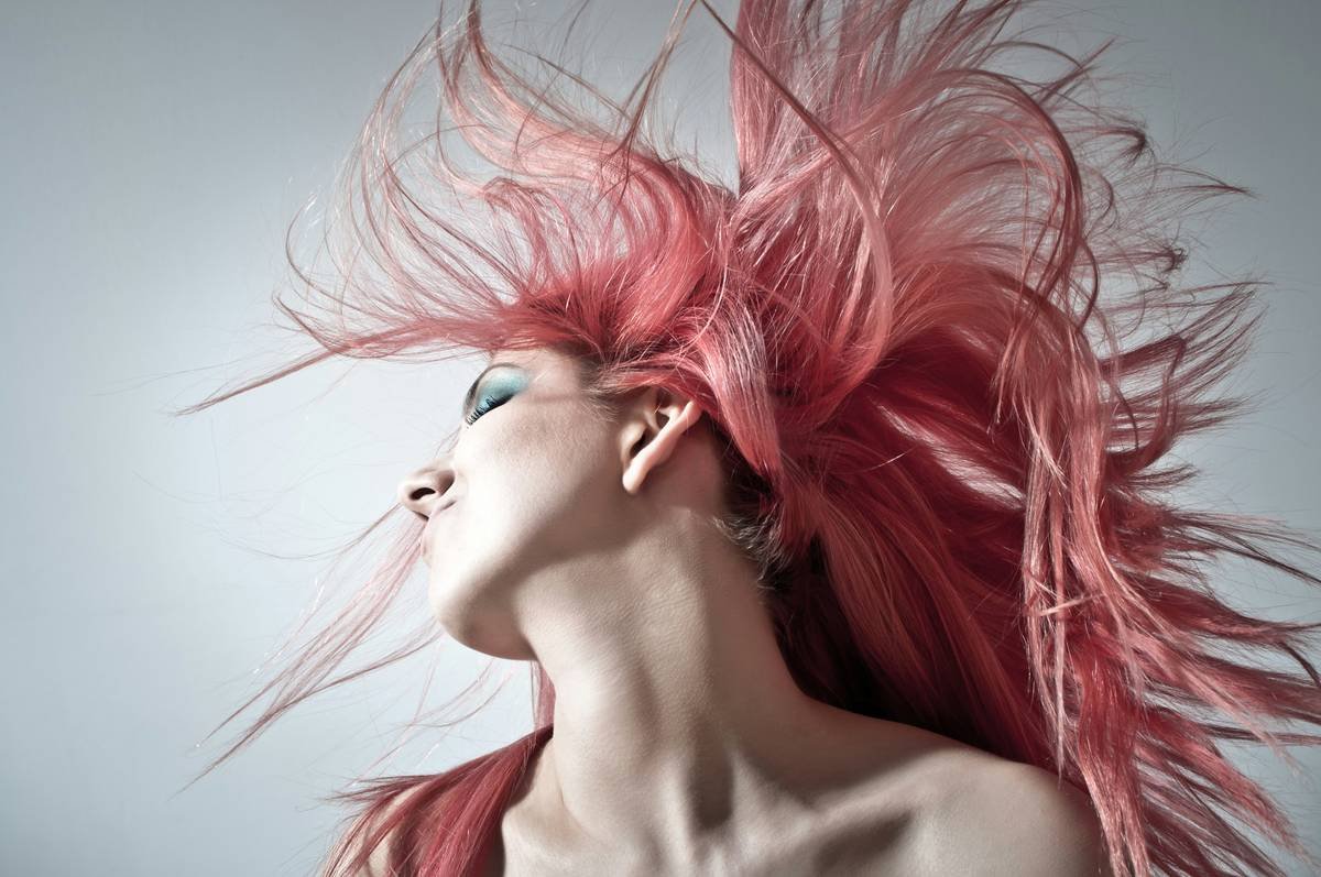 Stylist demonstrating proper placement of ponytail extension trends for natural movement
